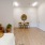 a room with a wood floor and a round table and chairs and a lamp